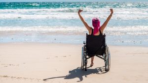 אשה בכסא גלגלים על החוף - ביטוח אובדן כושר עבודה